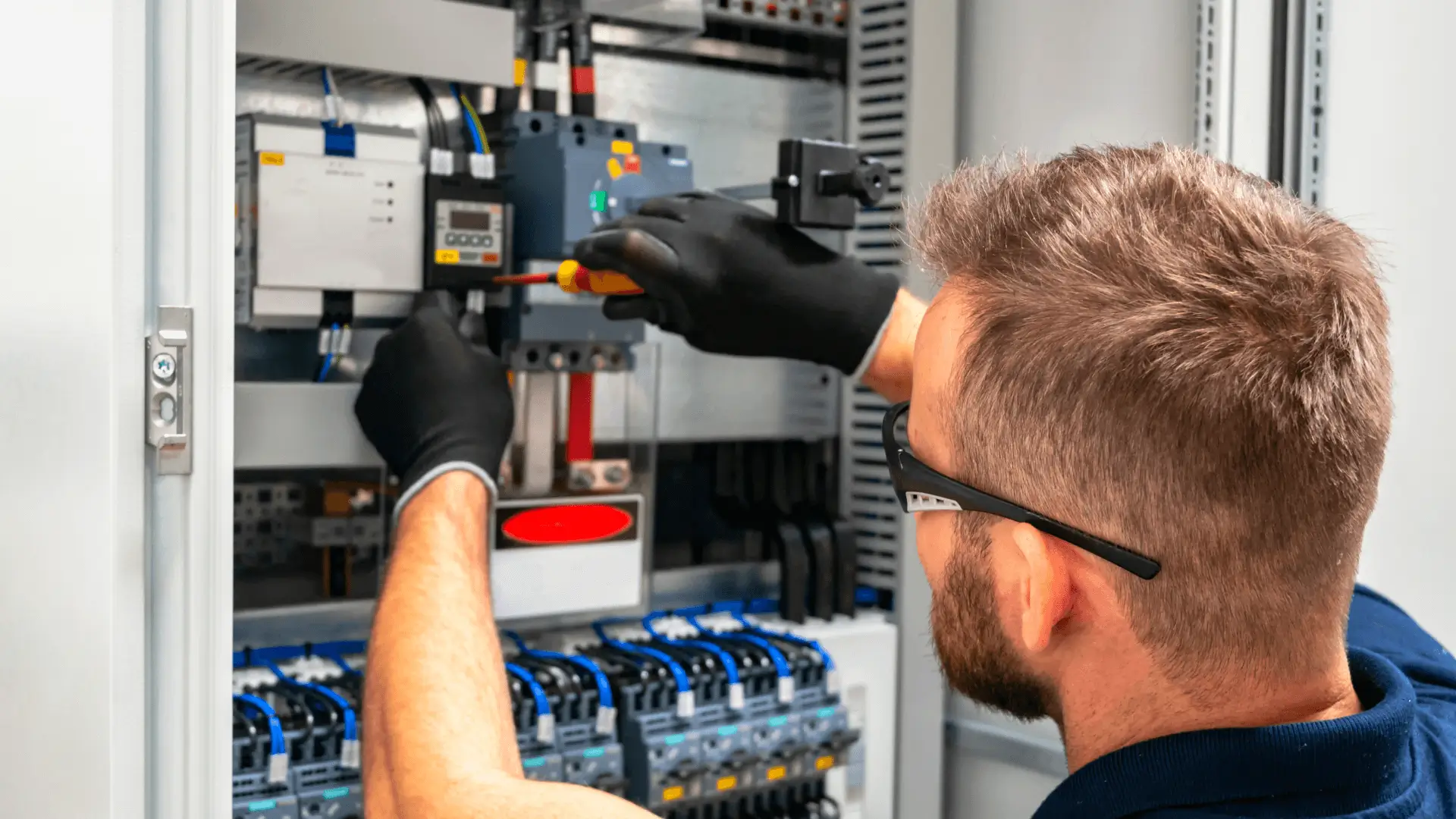 Technician working on electrical control equipment
