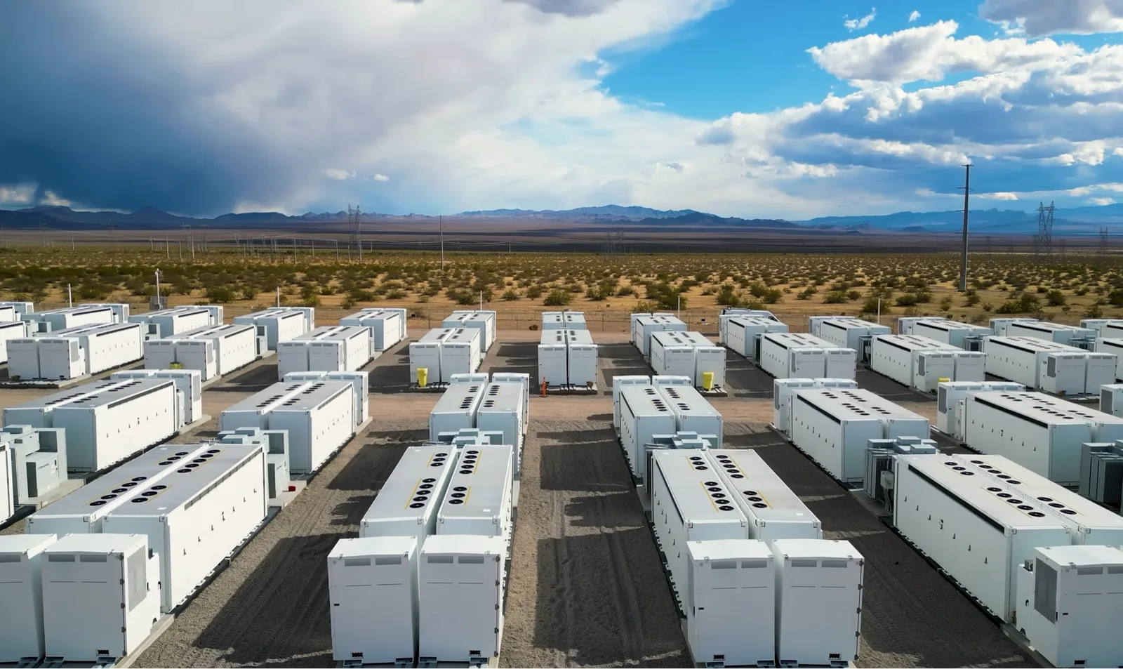 Rows of utility-scale battery energy storage enclosures at an outdoor facility